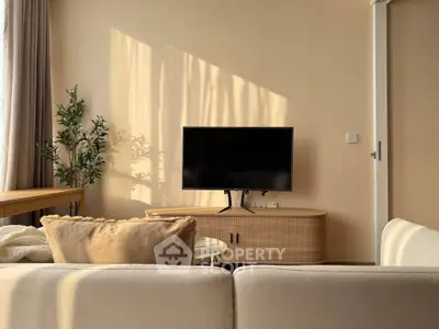 Cozy living room with modern TV setup and natural light