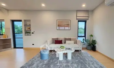 Spacious modern living room with stylish decor and large windows offering natural light.