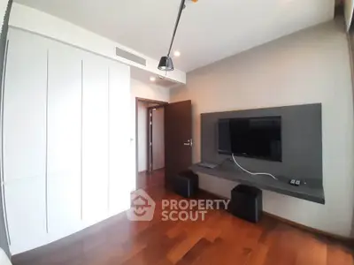 Modern living room with sleek TV setup and wooden flooring