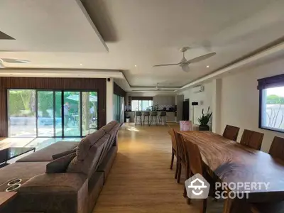 Spacious open-plan living and dining area with modern furnishings and large windows.