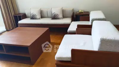 Elegant living room with wooden furniture and cozy seating area.