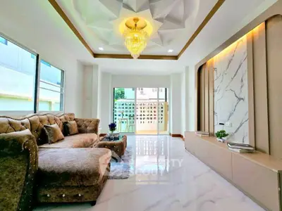 Luxurious living room with elegant chandelier and plush seating in modern home.