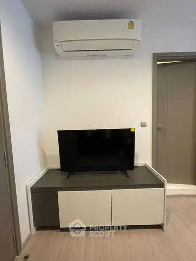 Modern living room with sleek TV unit and air conditioning, perfect for comfortable living.