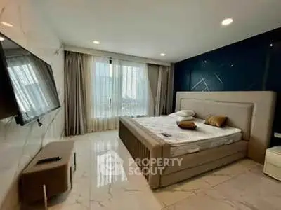 Luxurious bedroom with modern decor and large window offering natural light.