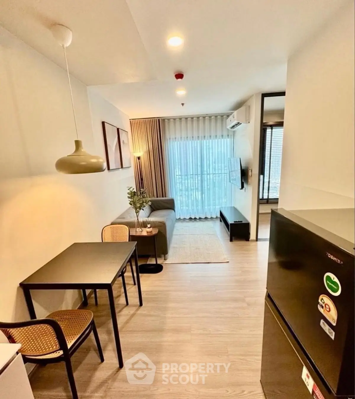 Modern living room with cozy seating and dining area, featuring stylish decor and natural light.