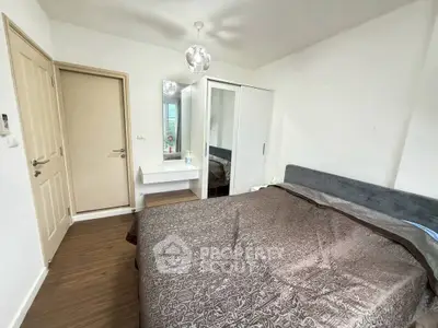 Cozy bedroom with modern decor and ample natural light, featuring a stylish bed and sleek wardrobe.