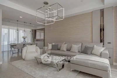 Elegant modern living room with stylish furniture and open dining area, featuring neutral tones and chic decor.