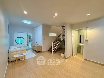 Spacious modern living room with staircase and pool view, perfect for family gatherings.