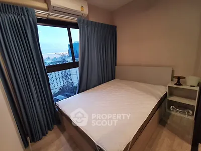 Cozy bedroom with city view, featuring a comfortable bed and modern decor, perfect for urban living.
