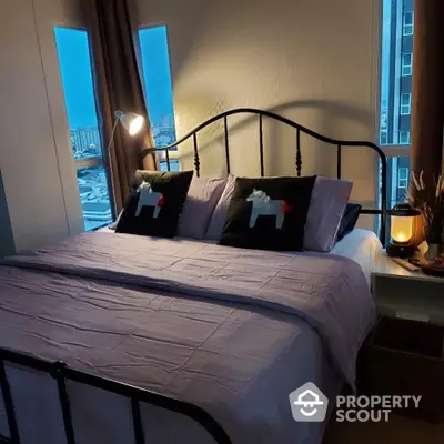 Cozy bedroom with city view and stylish decor, perfect for urban living.