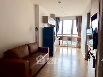 Modern apartment living room with sleek furniture and large window view.
