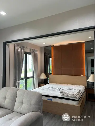 Modern bedroom with stylish decor and large windows in a contemporary apartment.