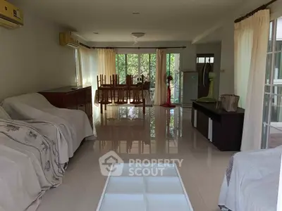 Spacious living room with elegant dining area and large windows for natural light.