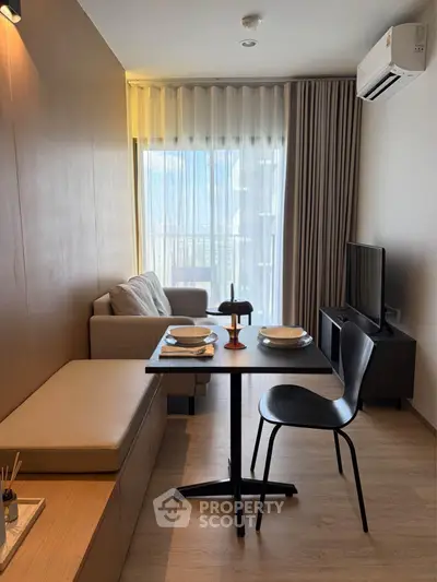 Modern living room with cozy seating and dining area, featuring natural light and stylish decor.