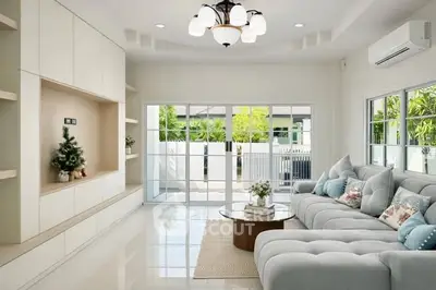 Spacious modern living room with plush sofa and large windows overlooking garden.