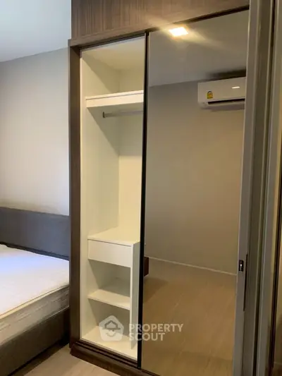 Modern bedroom with built-in wardrobe and air conditioning unit, perfect for comfortable living.