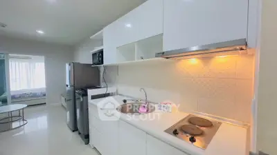 Modern kitchen with sleek white cabinets and electric stove in a bright apartment