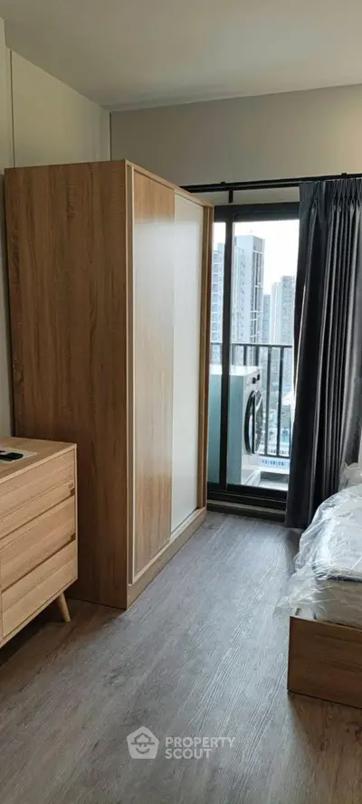 Modern bedroom with wooden furniture and balcony view in urban apartment