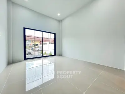 Spacious modern living room with large window and glossy tiled floor