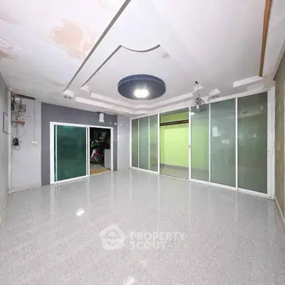 Spacious empty room with modern ceiling design and sliding glass doors