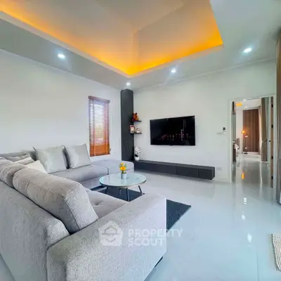 Modern living room with sleek design, cozy gray sectional sofa, and ambient lighting.
