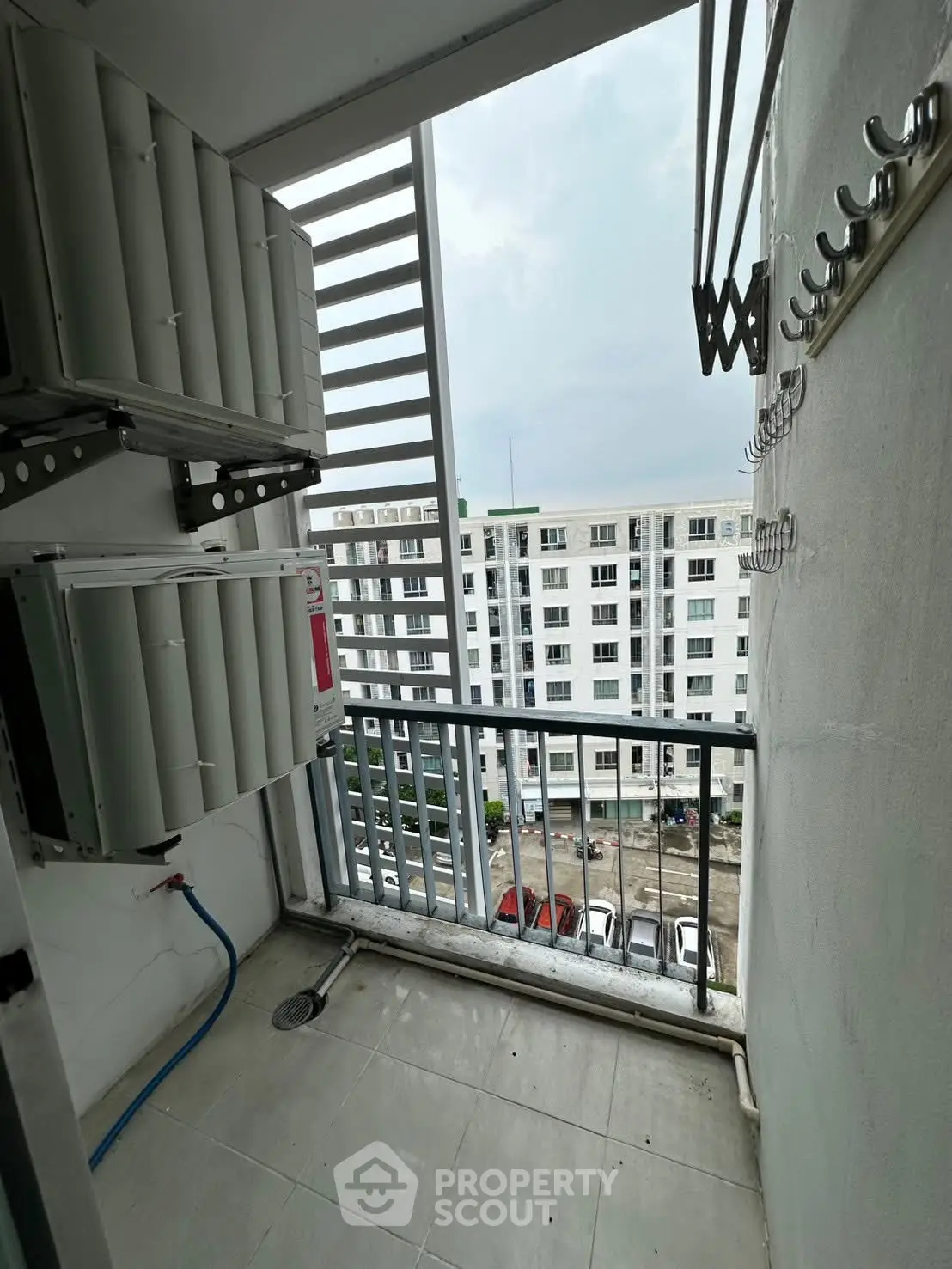 Compact balcony with city view, ideal for urban living, featuring utility space and railing.