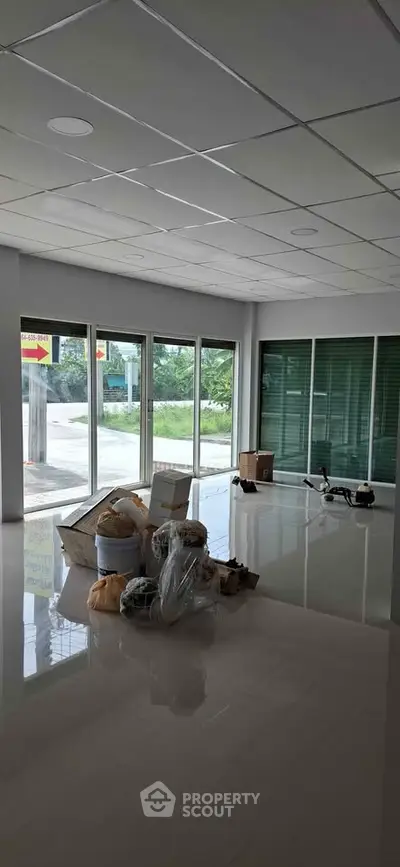 Spacious commercial space with large windows and glossy floors, ideal for retail or office setup.