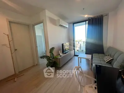 Modern living room with balcony view, sleek furniture, and natural light.