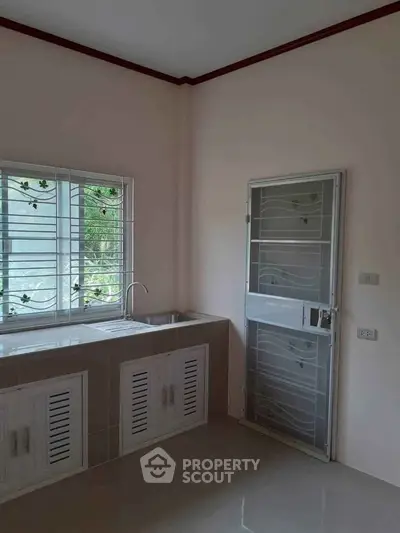 Bright kitchen with window view and modern sink in minimalist design.