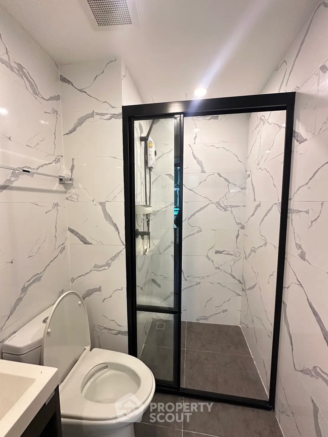 Modern bathroom with marble tiles and glass shower enclosure