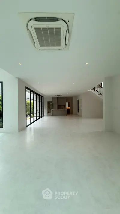 Spacious modern living room with large windows and open layout, perfect for natural light and contemporary living.