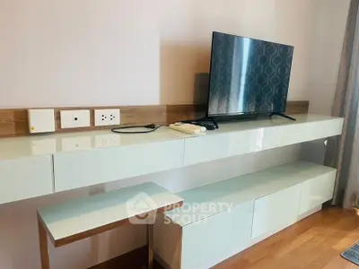 Modern living room with sleek TV stand and mounted flat-screen TV, showcasing contemporary design and functionality.