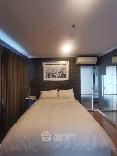 Cozy bedroom with modern decor and mirrored wardrobe in stylish apartment.