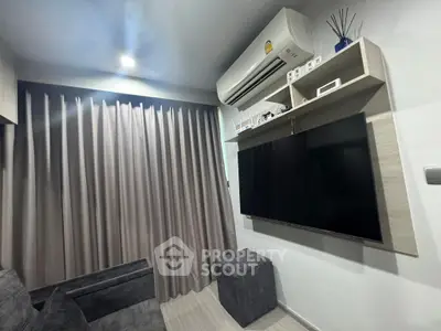 Modern living room with sleek design, featuring a large TV and air conditioning unit.