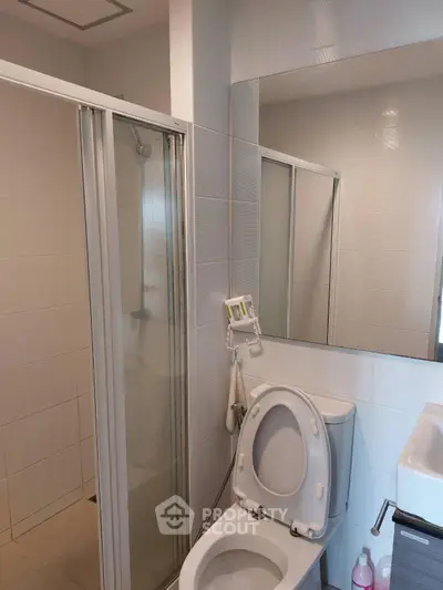 Modern bathroom with shower and toilet in a sleek, minimalist design.