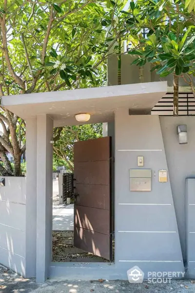 Modern entrance gate with sleek design and lush greenery