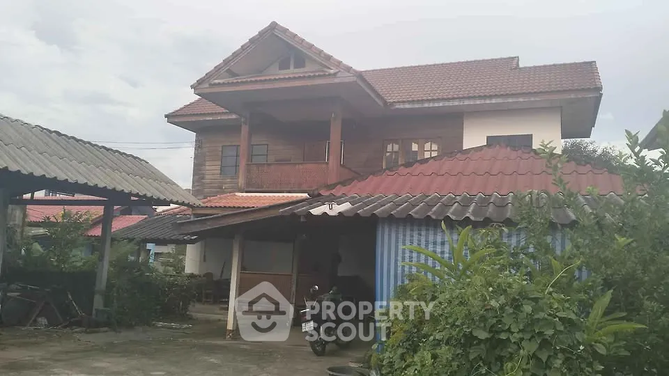 Charming two-story house with traditional architecture and lush greenery.