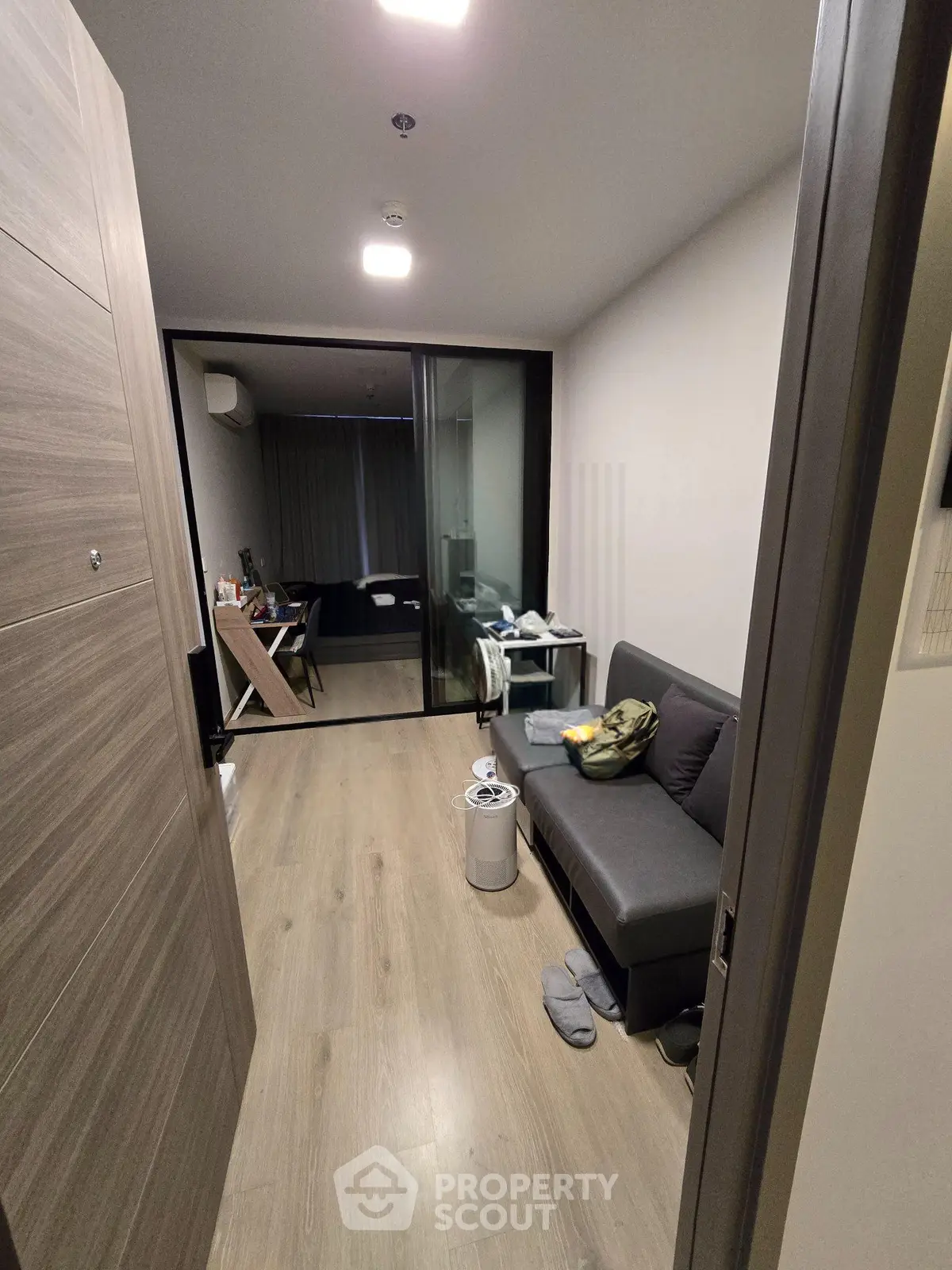 Modern apartment interior with sleek design and cozy living area, featuring a stylish sofa and wooden flooring.