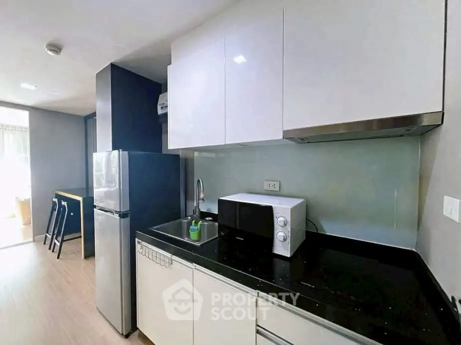 Modern kitchen with sleek cabinets and appliances in a stylish apartment.