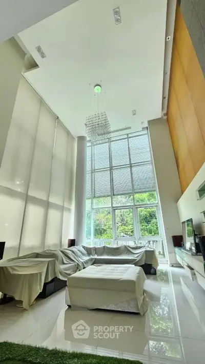 Luxurious living room with high ceilings and large windows offering stunning natural light.