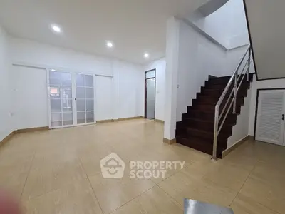 Spacious modern living room with wooden staircase and sliding glass doors