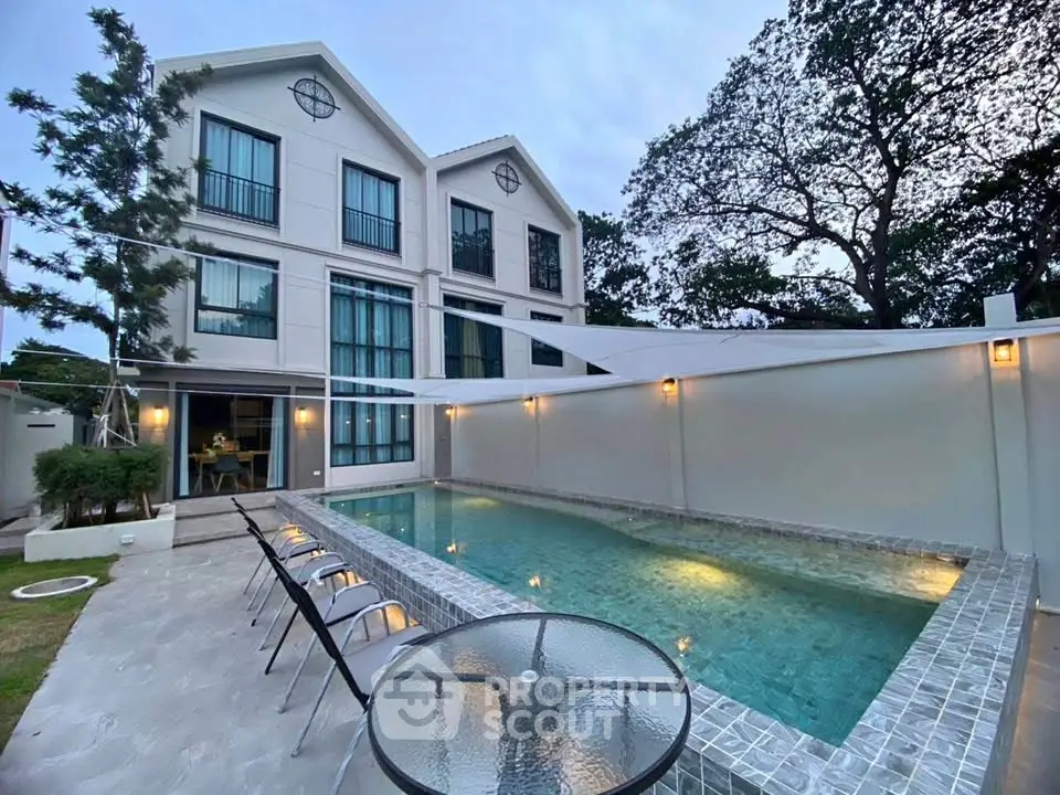 Luxurious modern home with private pool and elegant outdoor seating area, perfect for relaxation and entertainment.