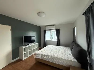 Spacious bedroom with modern decor and large window for natural light