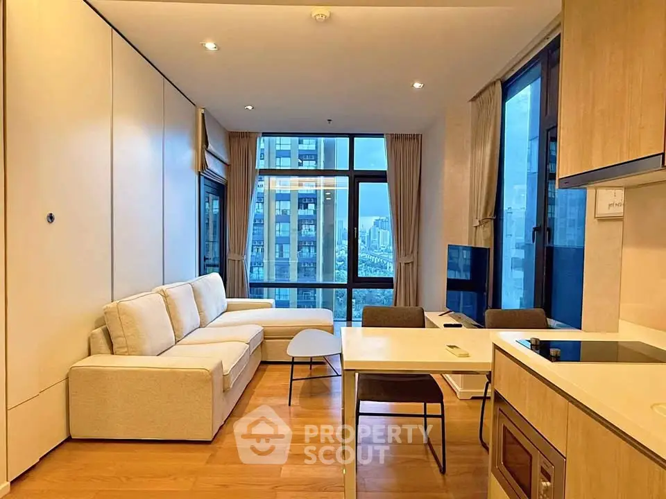 Modern living room with city view, featuring sleek furniture and open layout.
