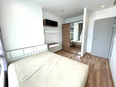 Modern minimalist bedroom with wooden flooring and built-in wardrobe