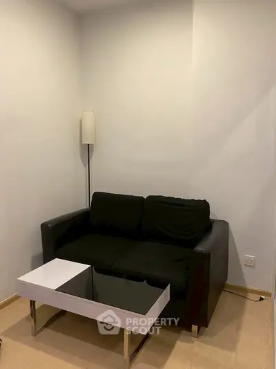 Cozy minimalist living room with black sofa and modern coffee table