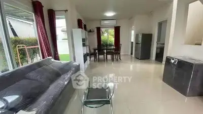 Spacious living room with modern furniture and large windows in a bright home.