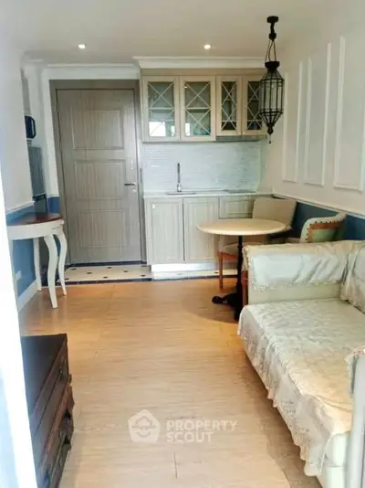 Charming small living room with cozy sofa and compact kitchen area, perfect for urban living.