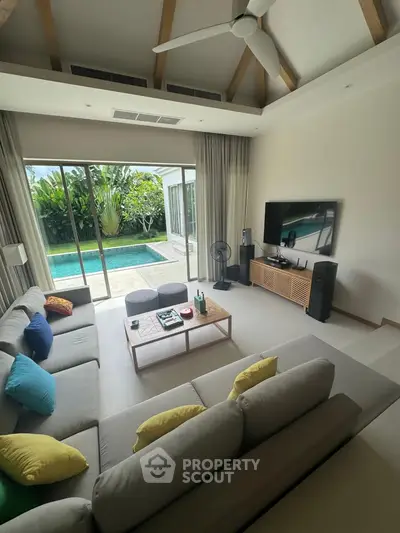 Luxurious living room with pool view, high ceiling, and modern decor in a tropical villa.