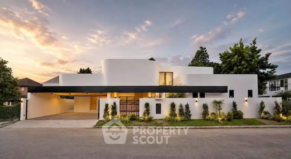 Stunning modern architectural home with sleek design and lush landscaping at sunset.